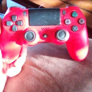 2 PlayStation 4 controllers a red one and a rose gold